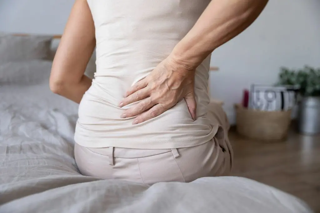 A woman sitting on the bed with her back turned.