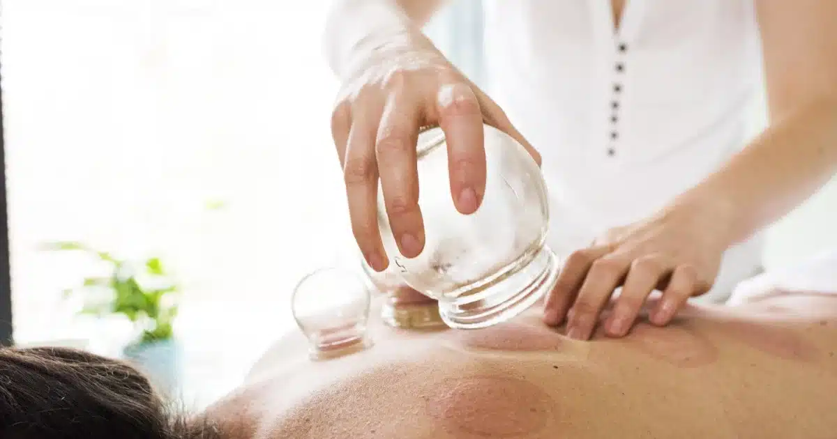 A person is holding an acupuncture device on their back.