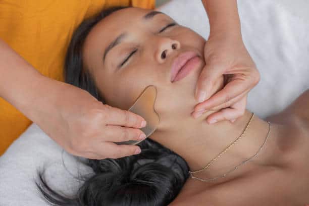 A woman getting her face waxed at the spa.