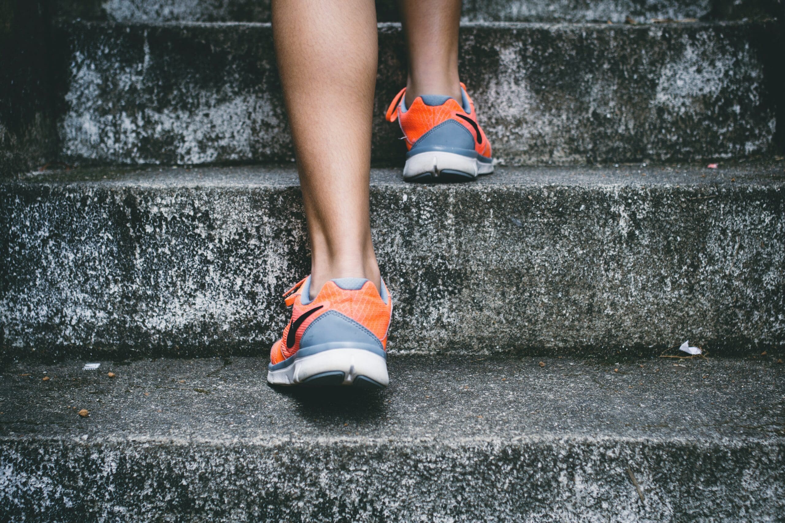 A person is walking up some stairs with their shoes on.