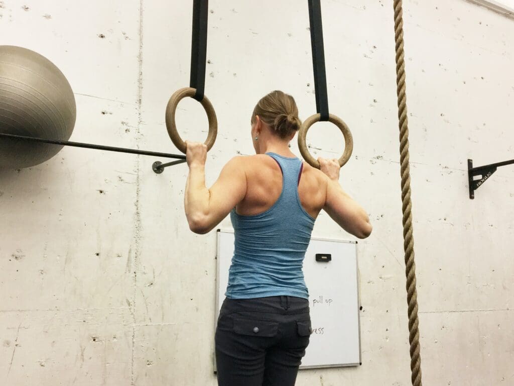 A woman is doing some gymnastics on rings