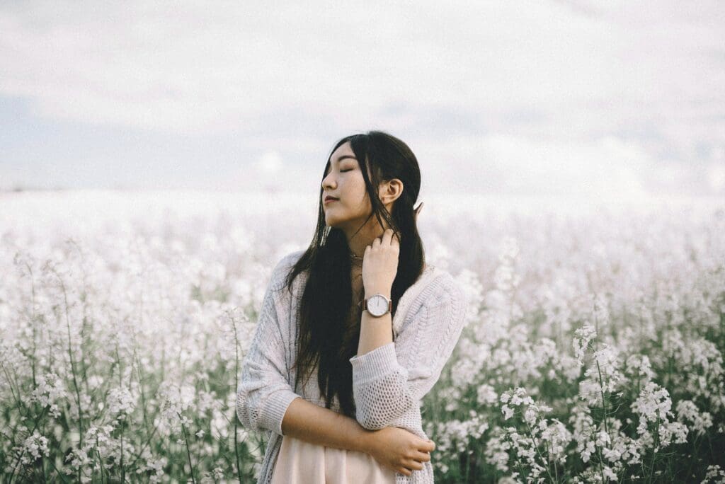 A woman standing in front of some flowers