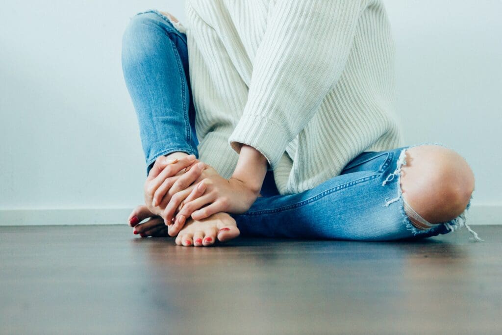 A person sitting on the ground with their feet crossed.