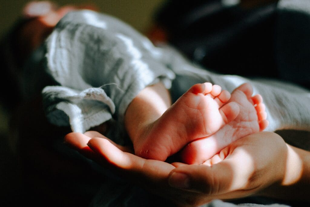 A baby 's foot in the palm of its mother.