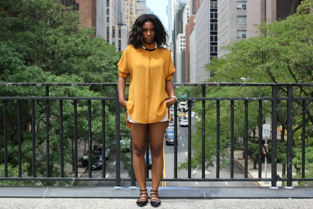 A woman standing on the side of a road.