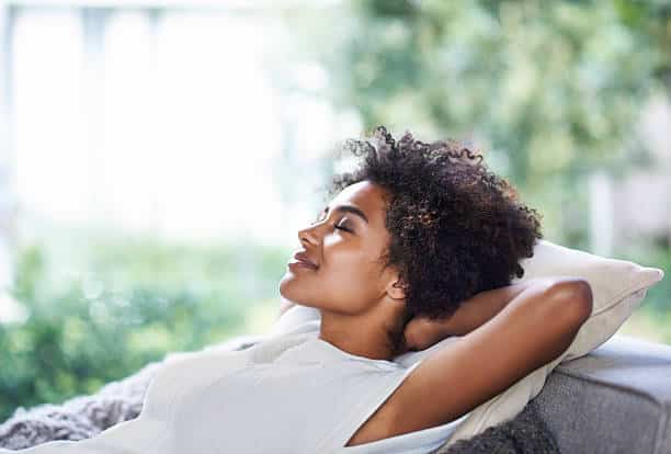 A woman laying on her stomach in the sun.