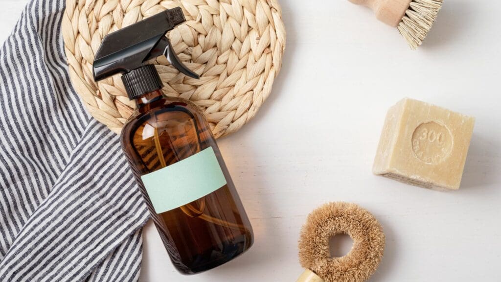 A bottle of cleaning product next to some hair brushes.