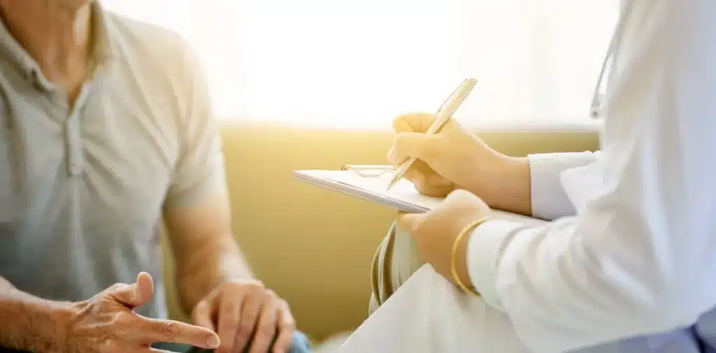 A person writing on paper while sitting down.