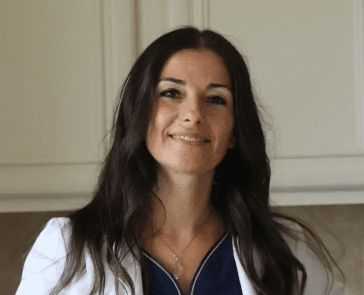 A woman with long hair wearing white and blue.