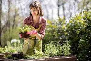 A woman holding a plant in her hands.