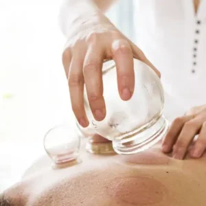 A person is holding an acupuncture device on their back.