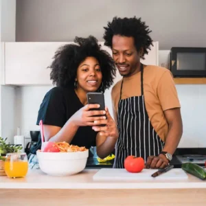 A man and woman are looking at a phone.