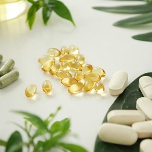 A table topped with lots of pills and green plants.