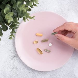 A person is holding onto some pills on the plate